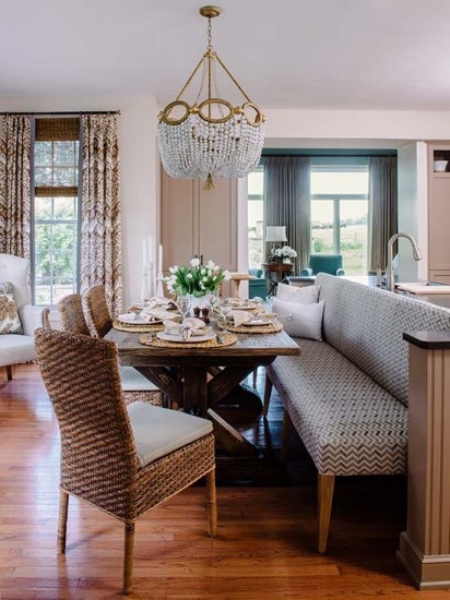 The Lee Industries armless bench is a perfect fit for the custom niche created in the island; its fabric is by JFF Fabrics. The Crate & Barrel rush chairs add texture, as does the Restoration Hardware X-table. / Photo by Robert Radifera